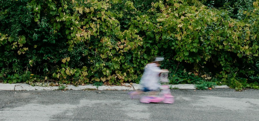 Little girl speeding past on a scooter