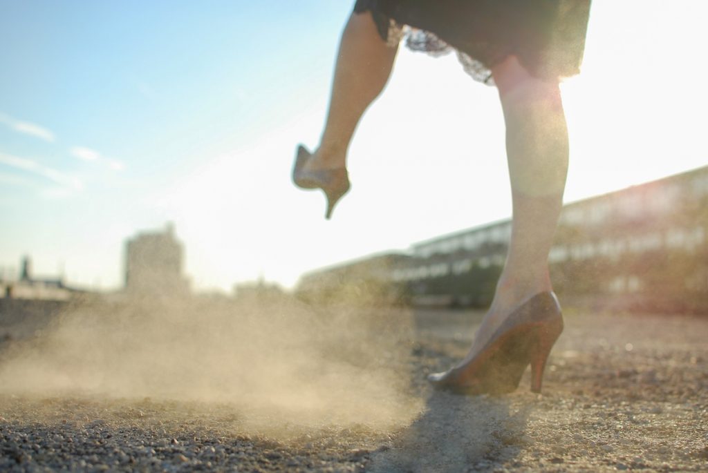 Woman in heels kicking dusty ground