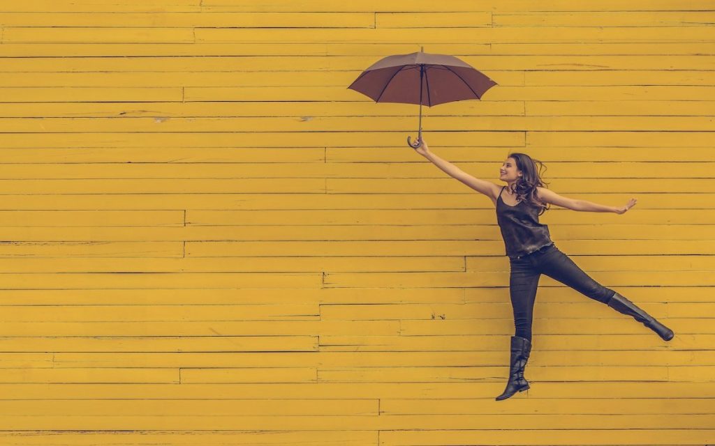 woman jumping happy with umbrella