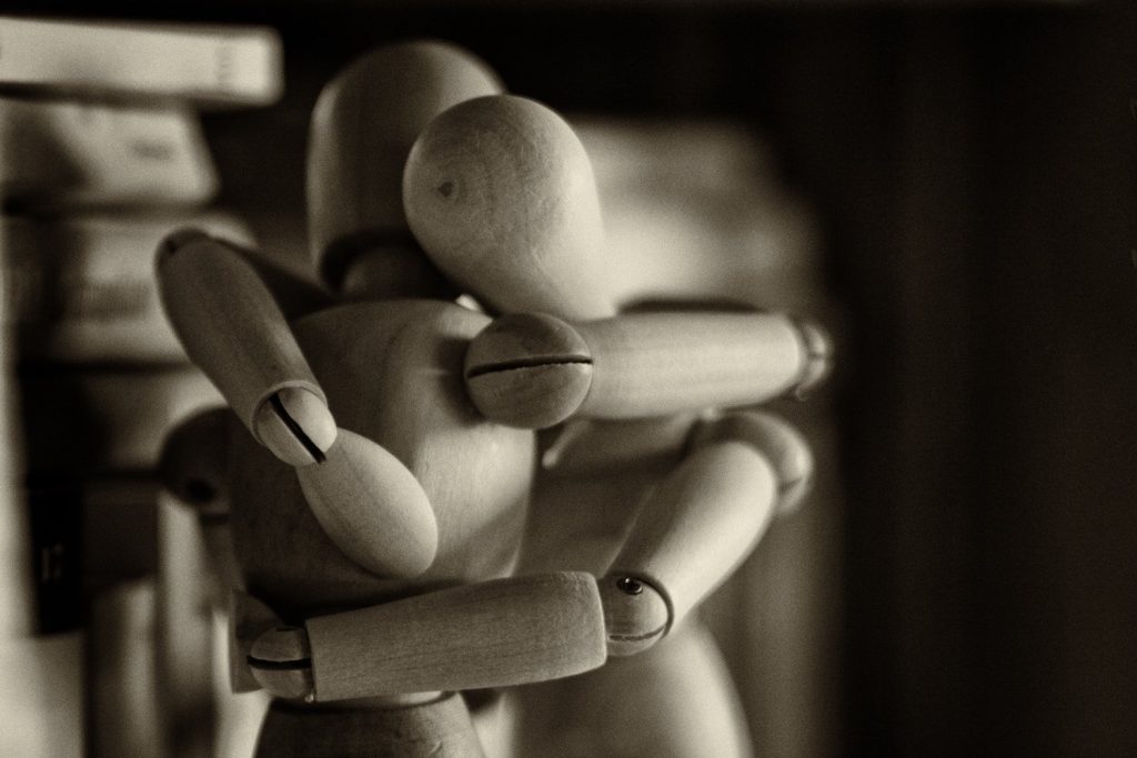 Two wooden mannequins hugging