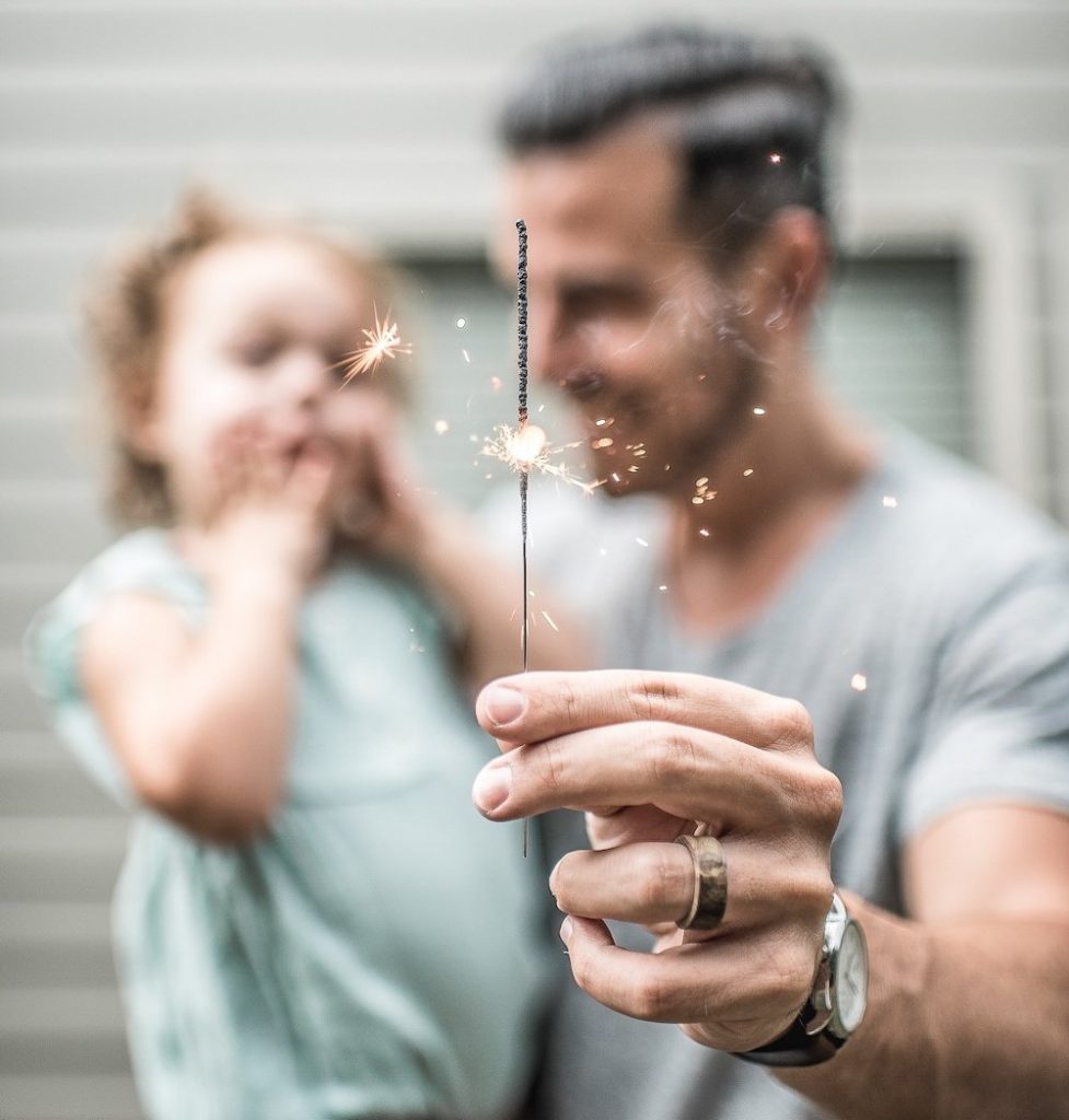 father and daughter holding a sprinkler