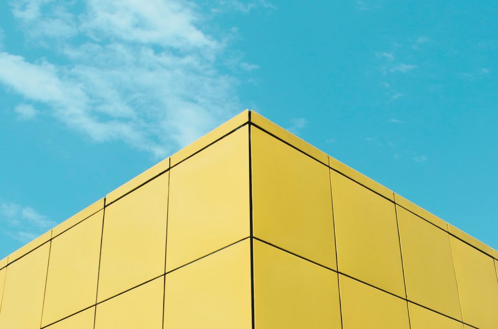 Side of yellow building against blue sky
