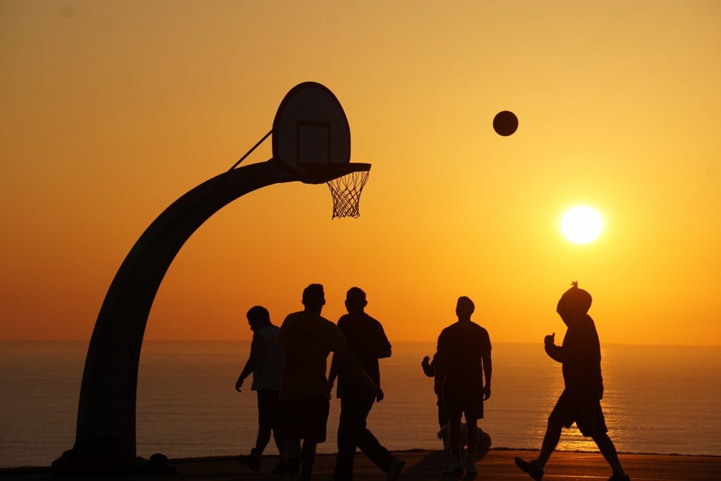 people playing basketball on the beach