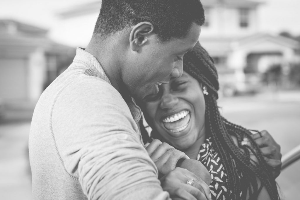 African man and woman laughing and hugging
