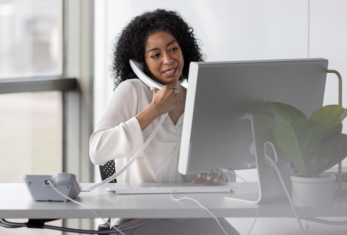 Mature female ABA provider speaks with colleagues while typing on keyboard