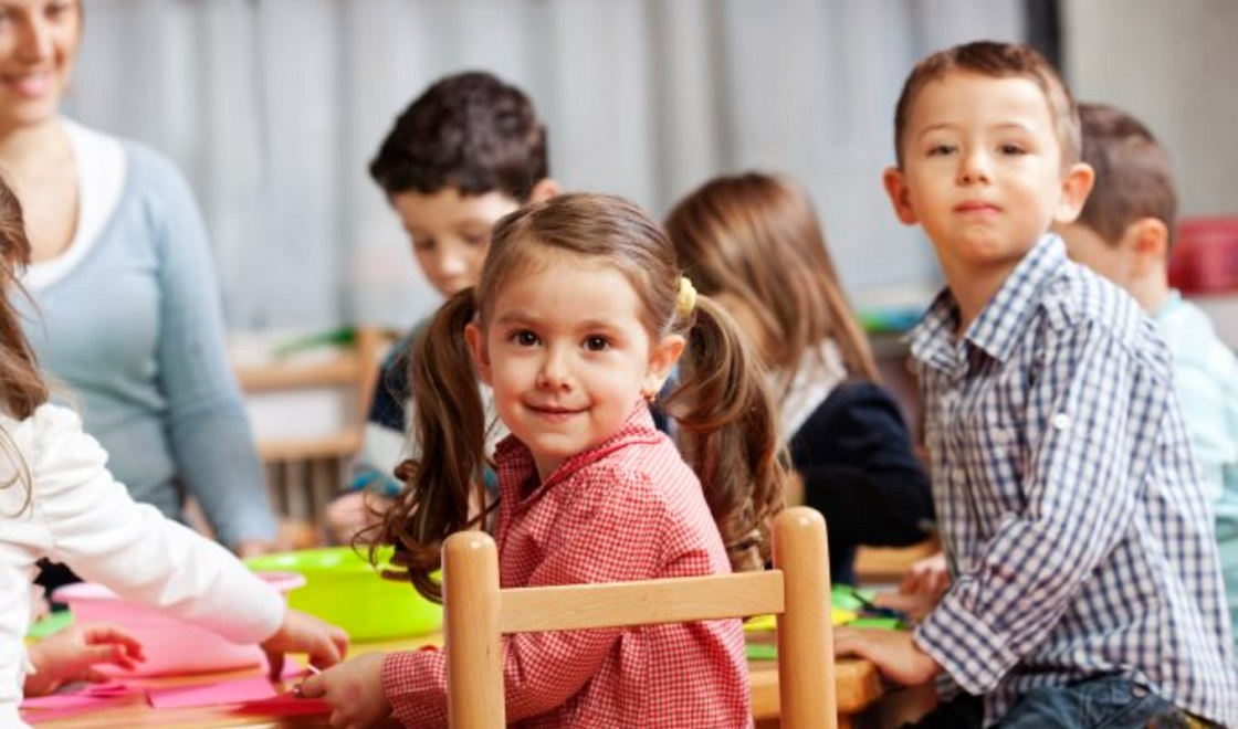 children smiling at camera in classroom