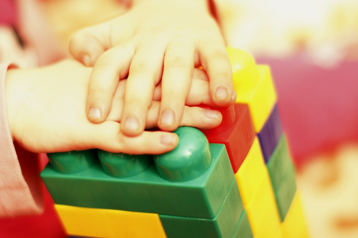 Close up of child's hands playing with colorful interlocking block toys