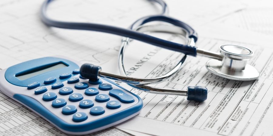 Medical papers, calculator and stethoscope on table