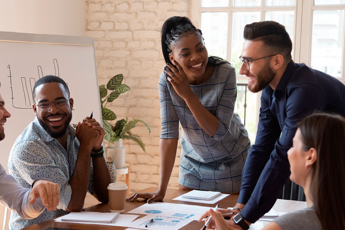 Happy meeting of millennial multiracial coworkers at brainstorming session in modern office