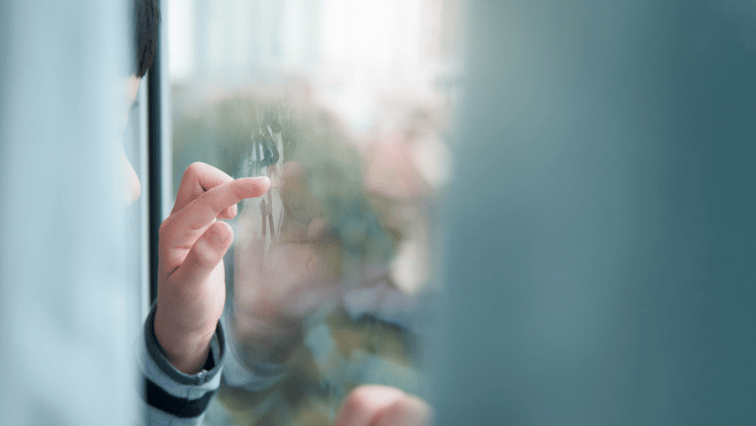 Autistic child fogging glass and making shapes