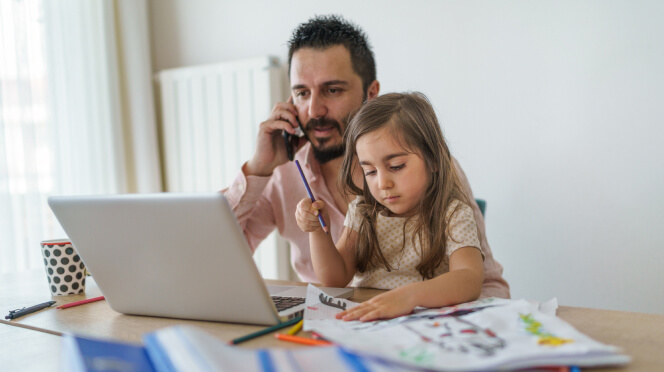Working parent father on laptop at home while daughter takes mental health day
