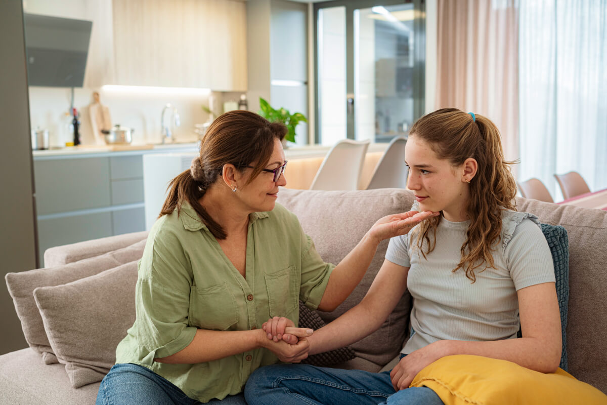 mother with daughter on couch talking to her about puberty