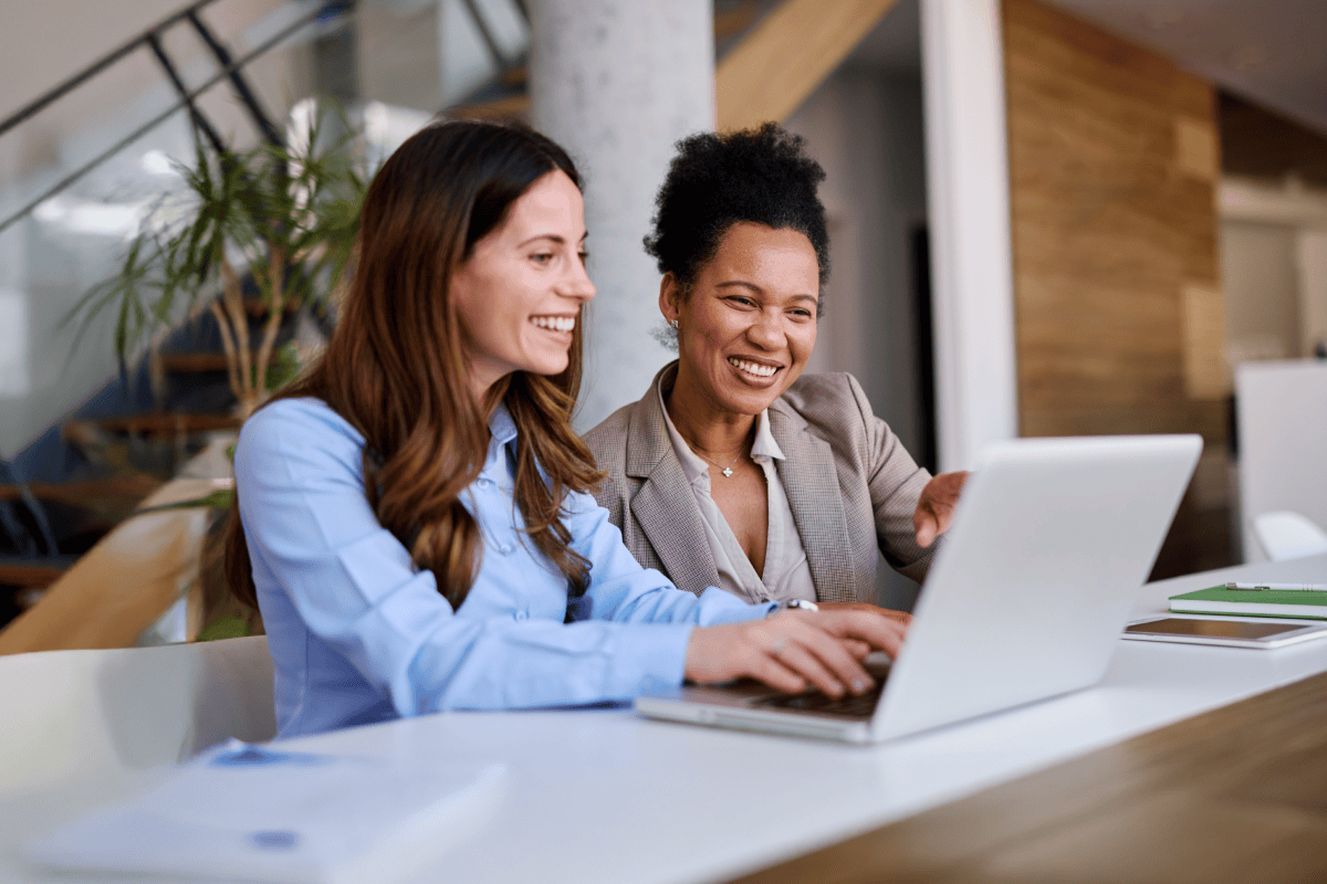 Two professionals collaborating on strategic planning using a laptop in a modern office.