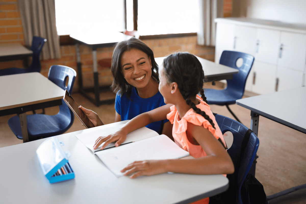 Teacher helping student review learning data in classroom